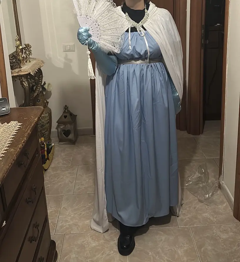 kobieta ubrana w regencyjną niebieską sukienkę oraz balowe rękawiczki