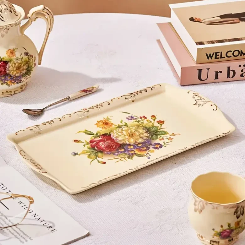 taca ze zdobieniami z eleganckiego zestawu do herbaty na białym stole obok książek