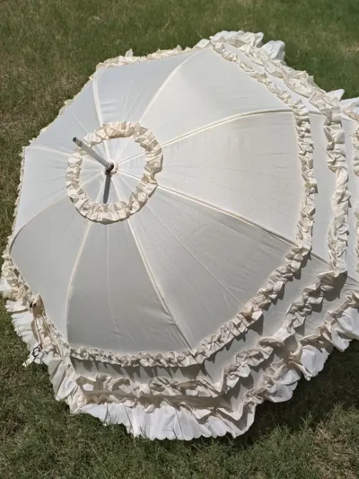 elegancka parasolka leżąca na trawie