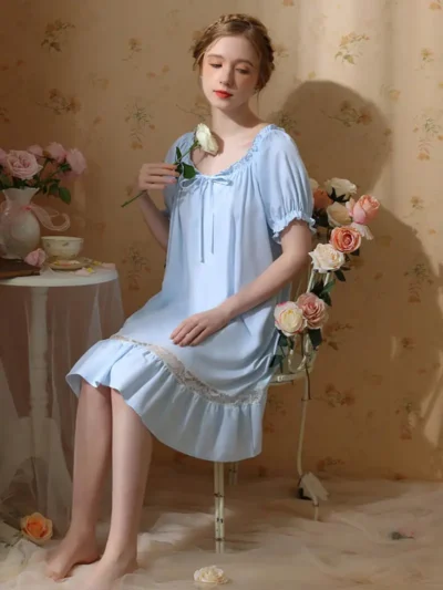 kobieta ubrana w jasnoniebieską koszulę nocną regencyjną siedząca na eleganckim krześle
