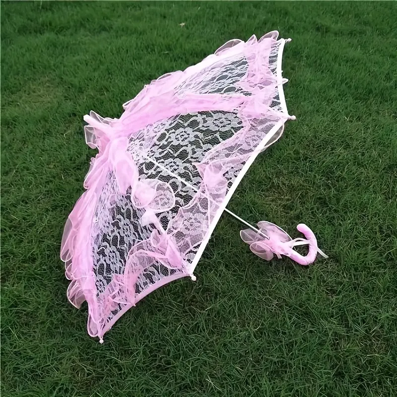 różowa parasolka koronkowa na trawie