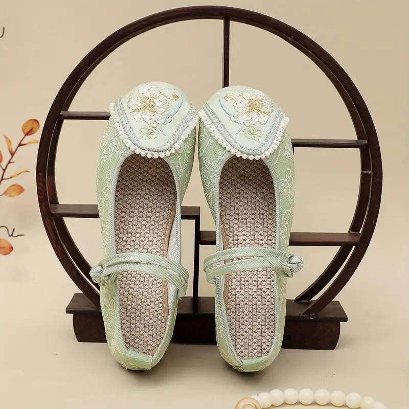 zielone buty vintage damskie do tańca oparte na drewnianej ramie na beżowym tle