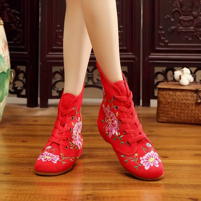 kobieta nosząca czerwone buty vintage damskie z haftem oraz krzyżująca nogi