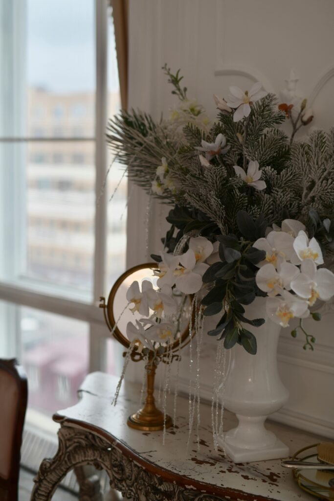 starodawne lusterko na drewnianej komodzie w starym stylu otoczone kwiatami obrazujące, co to jest styl vintage