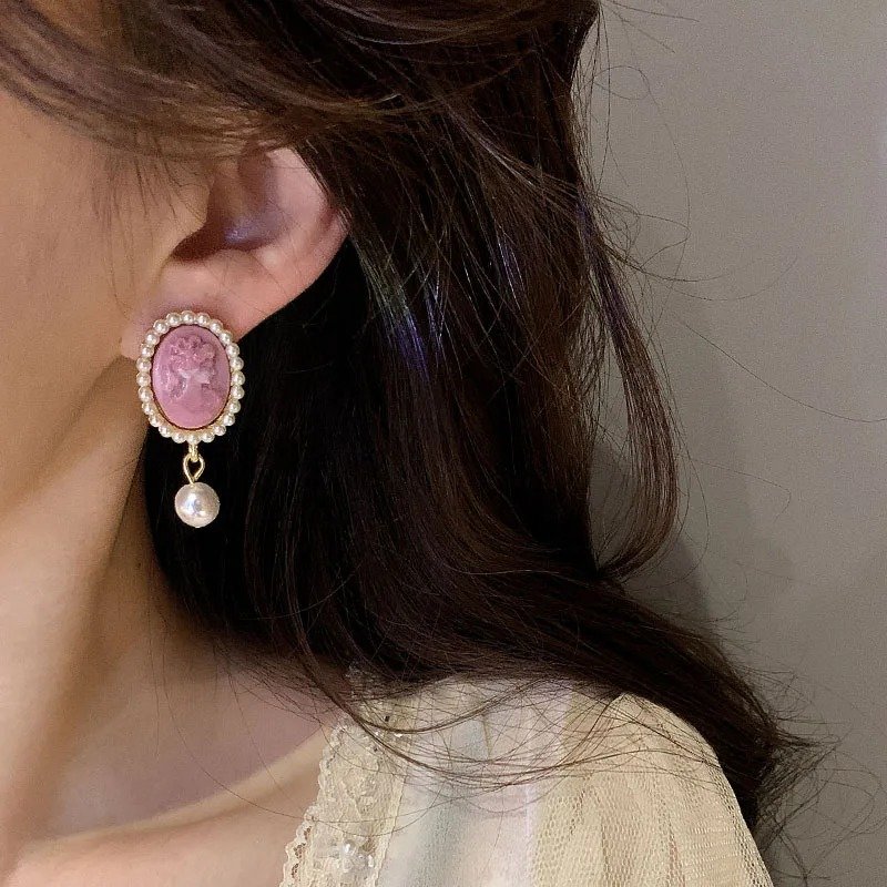 różowe francuskie kolczyki vintage w uchu kobiety