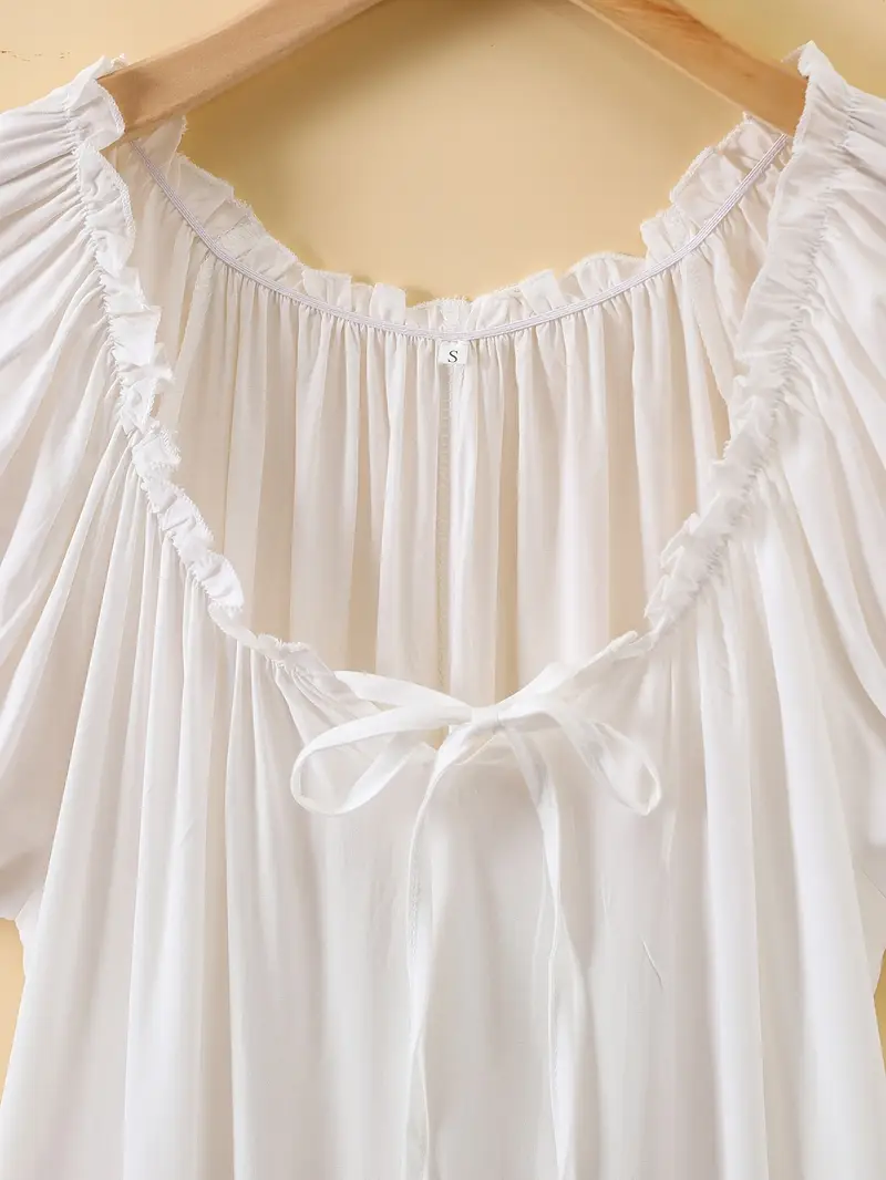 kołnierz oraz kokarda klasycznej koszuli nocnej na drewnianym wieszaku