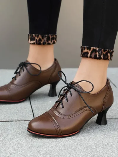 kobieta nosząca brązowe klasyczne buty vintage damskie na szarym chodniku