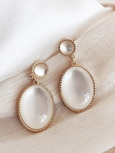 kolczyki vintage z kamieniem na beżowym materiale