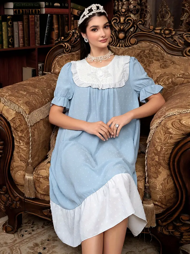 kobieta ubrana w koszulę do spania w kolorze jasnoniebieskim siedząca na dużym brązowym fotelu vintage