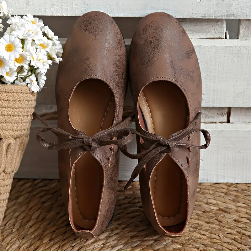brązowe starodawne sznurowane buty vintage damskie oparte o białe deski