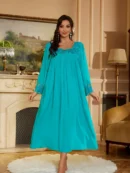 kobieta nosząca turkusową koszulę nocną w beżowym salonie