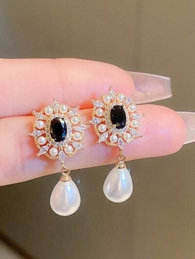 wiszące kolczyki vintage w dłoni kobiety