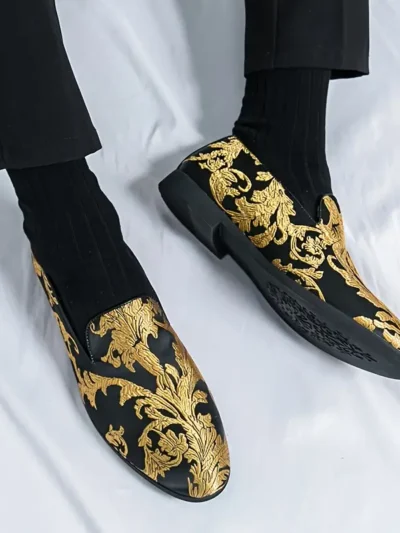 mężczyzna noszący złoto-czarne buty vintage męskie do eleganckich czarnych spodni