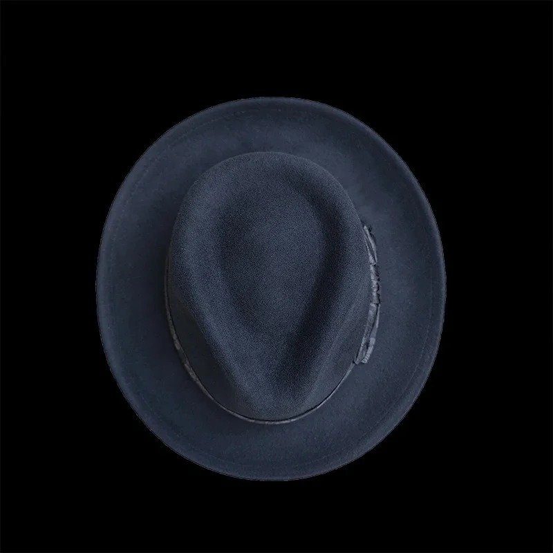 góra czarnego męskiego kapelusza na czarnym tle