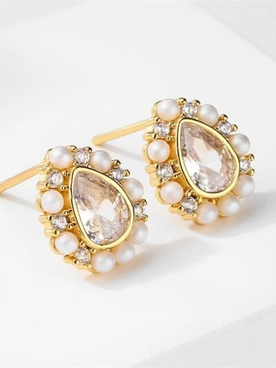 złote kolczyki retro obrócone bokiem na białym tle