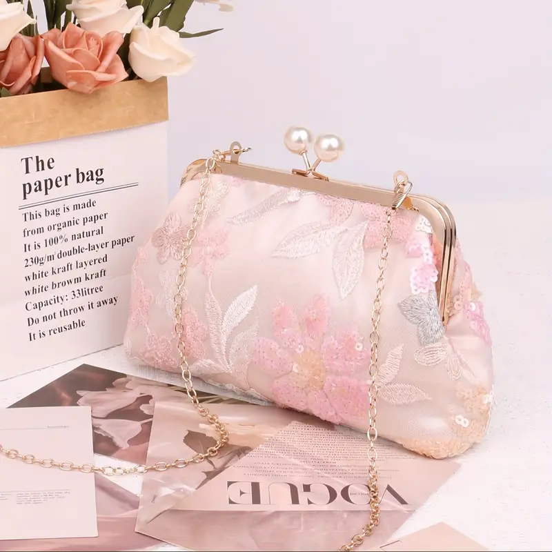 różowa zdobiona kopertówka vintage postawiona na lśniącej powierzchni obok gazet