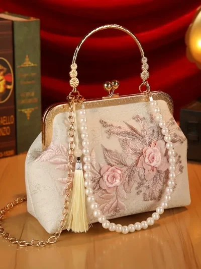 kwiatowa torebka vintage z różową haftowaną różą na drewnianym biurku