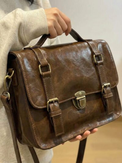 kobieta noszaca białą bluzę trzymająca brązową listonoszkę vintage