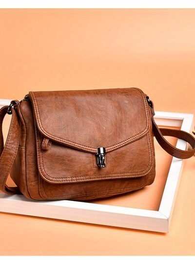 brązowa torba na ramię vintage na beżowym tle w białej ramce