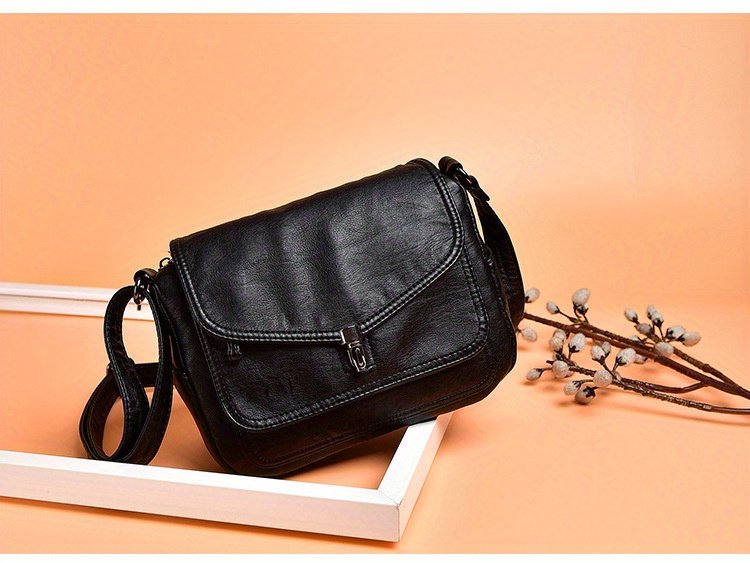 czarna torba na ramię vintage na beżowym tle w białej ramce