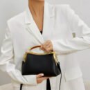 kobieta nosząca biały garnitur oraz czarną torebkę retro