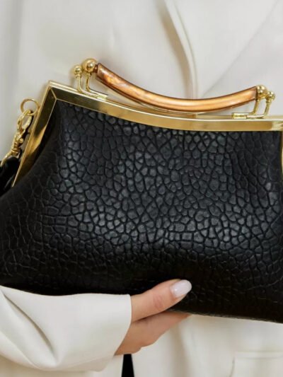 kobieta trzymająca torebkę retro w czarnym kolorze