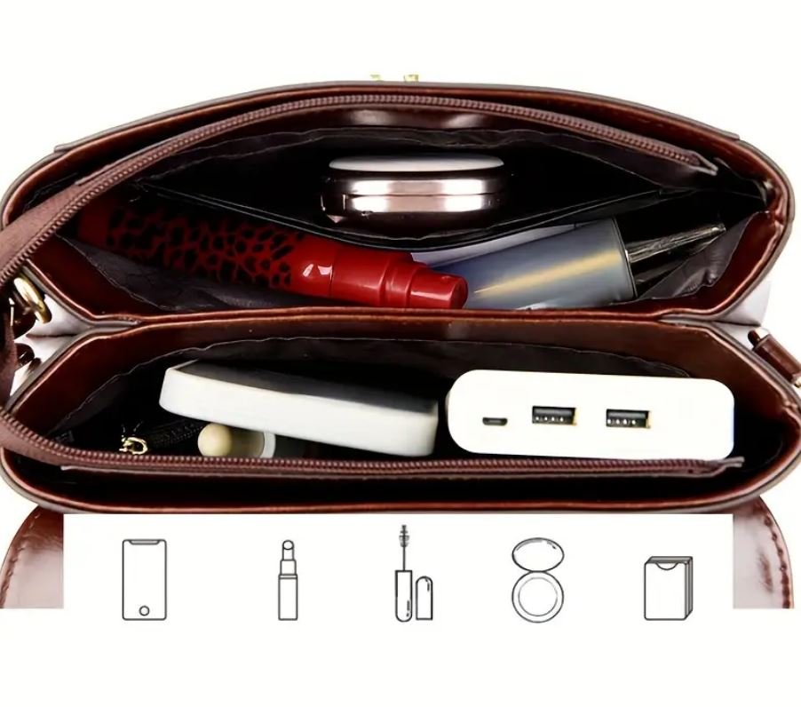 otwarta brązowa torebka vintage skórzana z telefonem, powerbankiem, błyszczykiem oraz innymi przedmiotami w środku