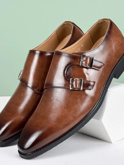 brązowe eleganckie buty vintage męskie oparte o biały walec na niebieskim tle