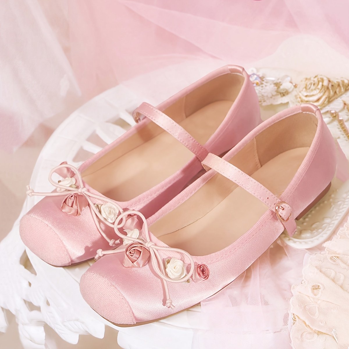 rózowe baleriny vintage położone na białym stoliku