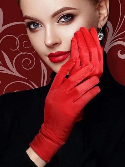 kobieta nosząca czerwone eleganckie rękawiczki balowe oraz przykładająca dłoń do twarzy