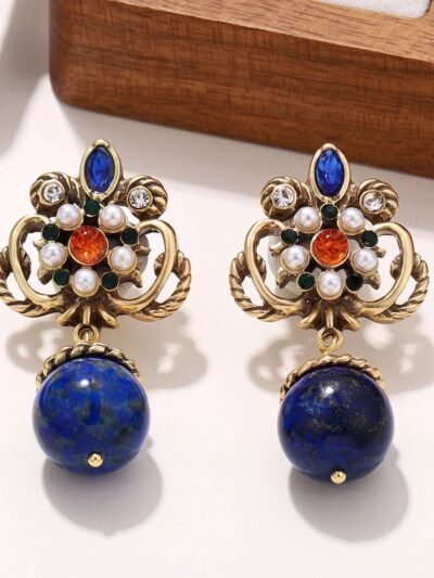kolorowe kolczyki vintage z granatowymi koralikami położone na białej powierzchni