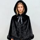 kobieta z blond słosami nosząca czarną krótką peleryną damską z kokardą