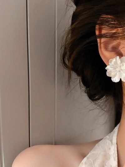 kobieta nosząca kwiatowe kolczyki vintage oraz białą suknię