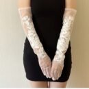 kobieta nosząca białe kwiatowe rękawiczki balowe oraz krótką czarną sukienkę