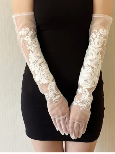 kobieta nosząca białe kwiatowe rękawiczki balowe oraz krótką czarną sukienkę