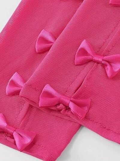 zbliżenie na materiał rózowych rękawiczek balowych z kokardami