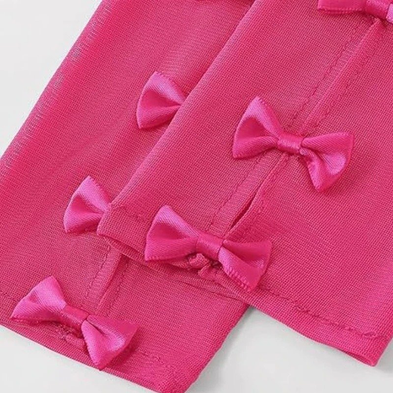 zbliżenie na materiał rózowych rękawiczek balowych z kokardami