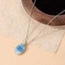 niebieski naszyjnik vintage położony na beżowym stole