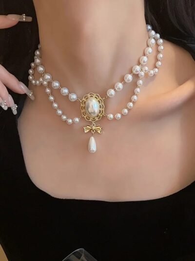 kobieta nosząca perłowy regencyjny naszyjnik vinage oraz czarny top