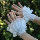 kobieta nosząca białe rękawiczki balowe z koronką, drzewa w tle