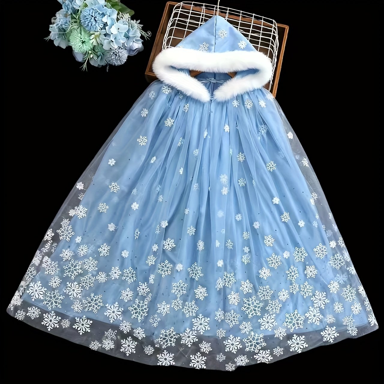 świąteczna peleryna położona na czarnym stole