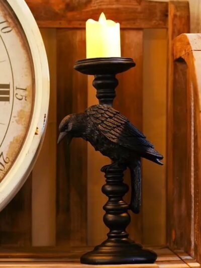 świecznik gotycki z palącą się świeczką połozony obok wielkiego zegara