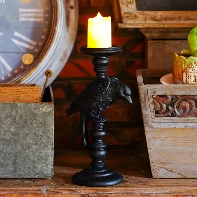 świecznik gotycki obrócony bokiem na stole obok doniczek