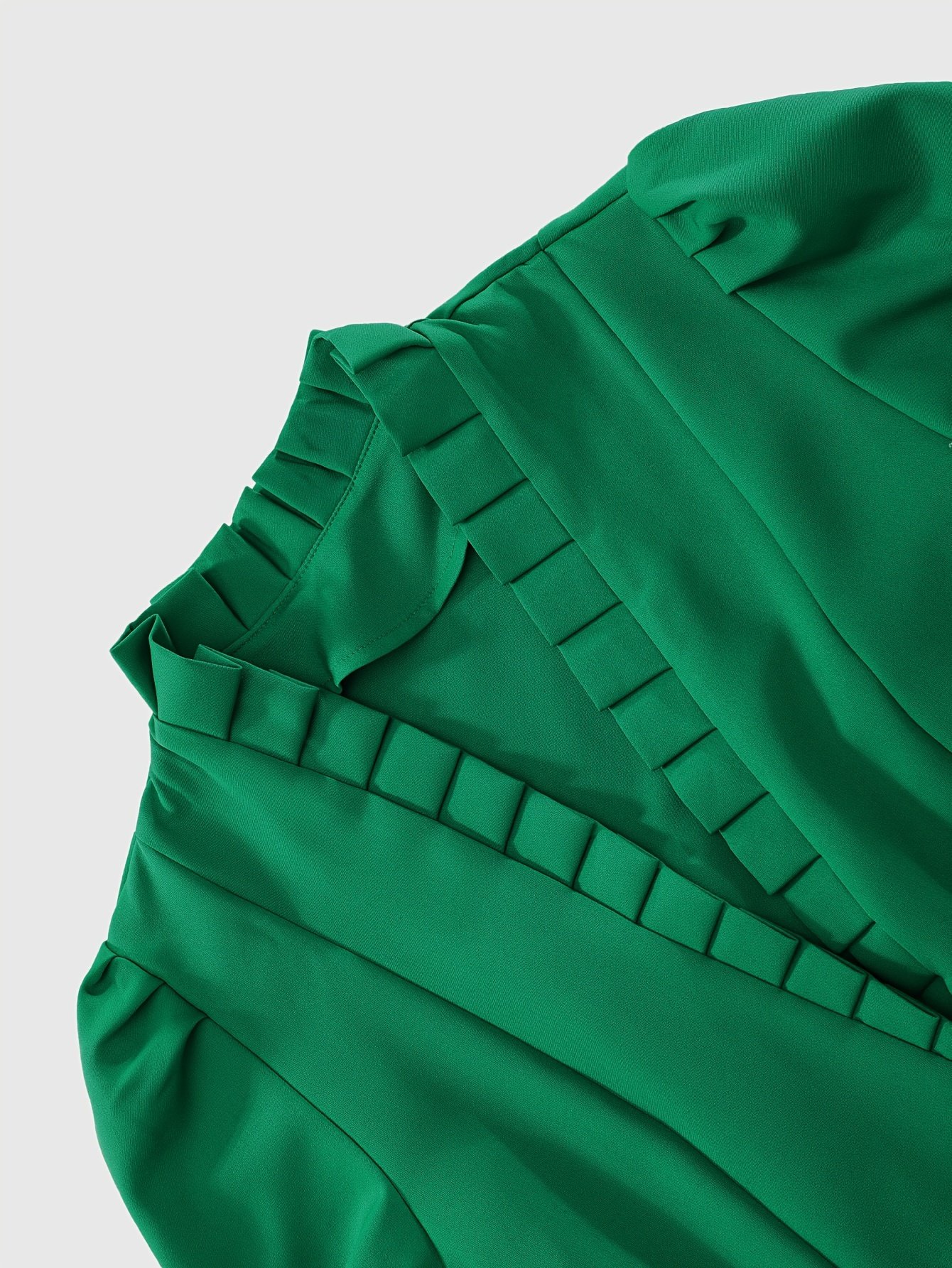 zbliżenie na materiał i falbany zielonej damskiej kurtki peleryny