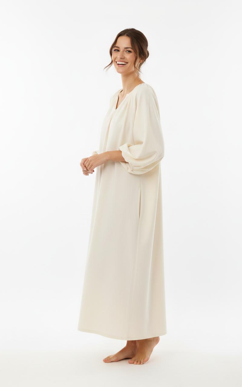 kobieta z brązowymi włosami obrócona bokiem nosząca białą bawełnianą koszulę nocną vintage na białym tle