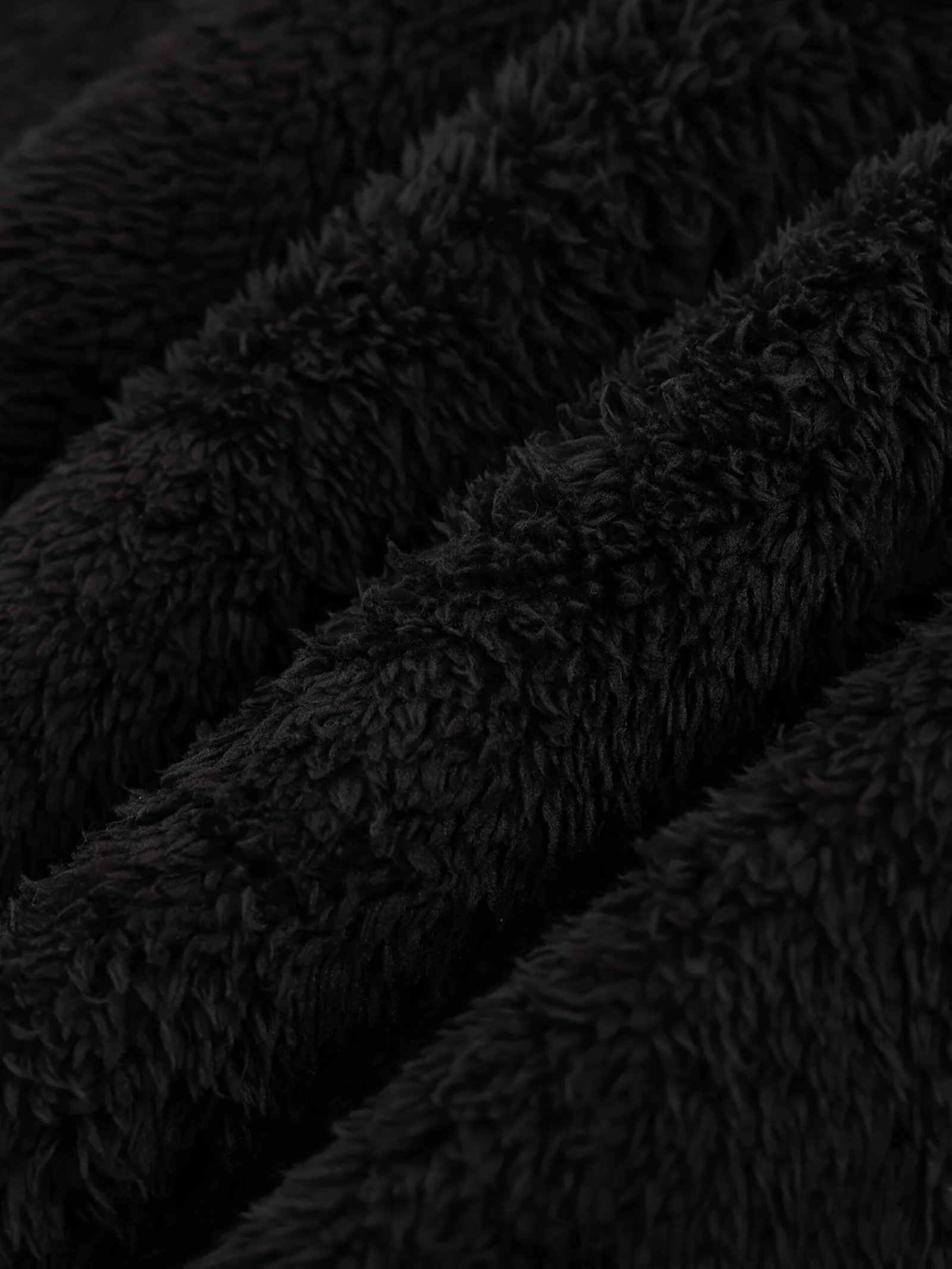 zbliżenie na czarny materiał ciepłej peleryny damskiej