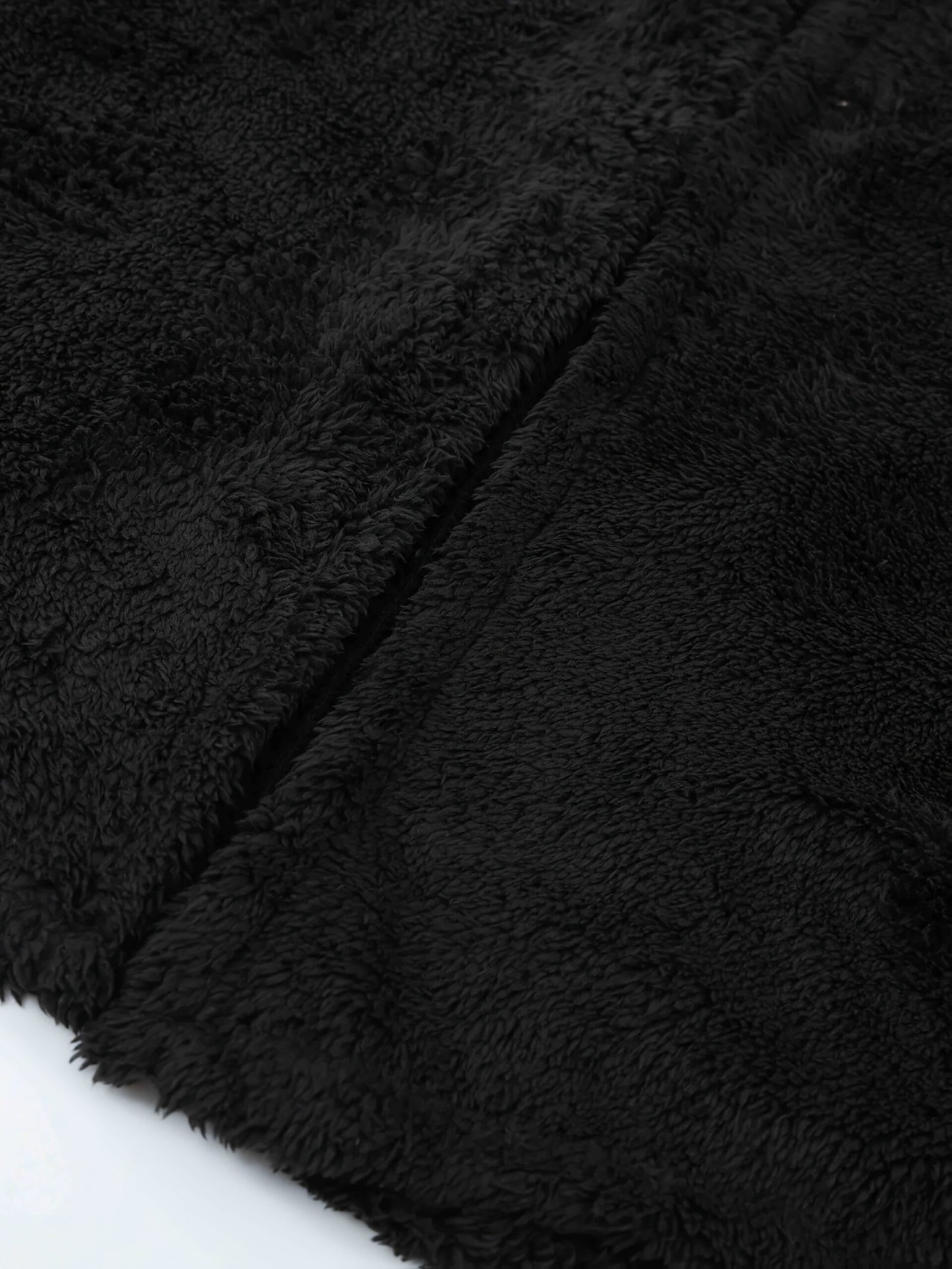 tekstura materiału czarnej ciepłej peleryny damskiej