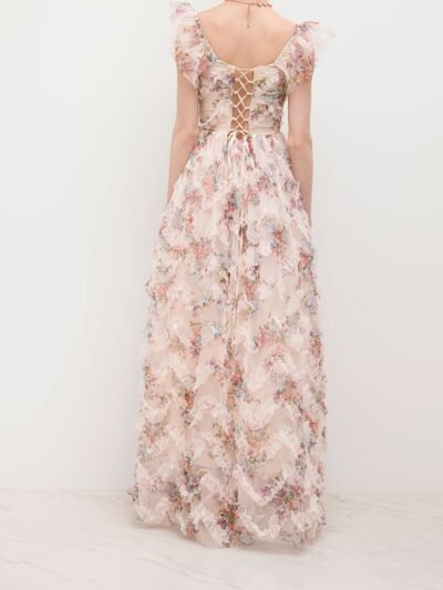 kobieta obrócona tyłem nosząca sukienkę vintage w kwiaty na białym tle