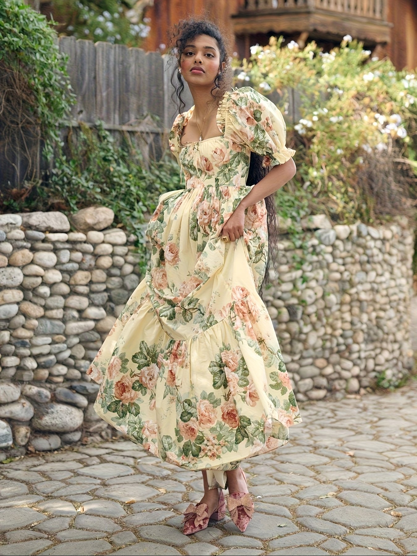 kobieta nosząca żółtą suknię balową midi w kwiaty na bruku